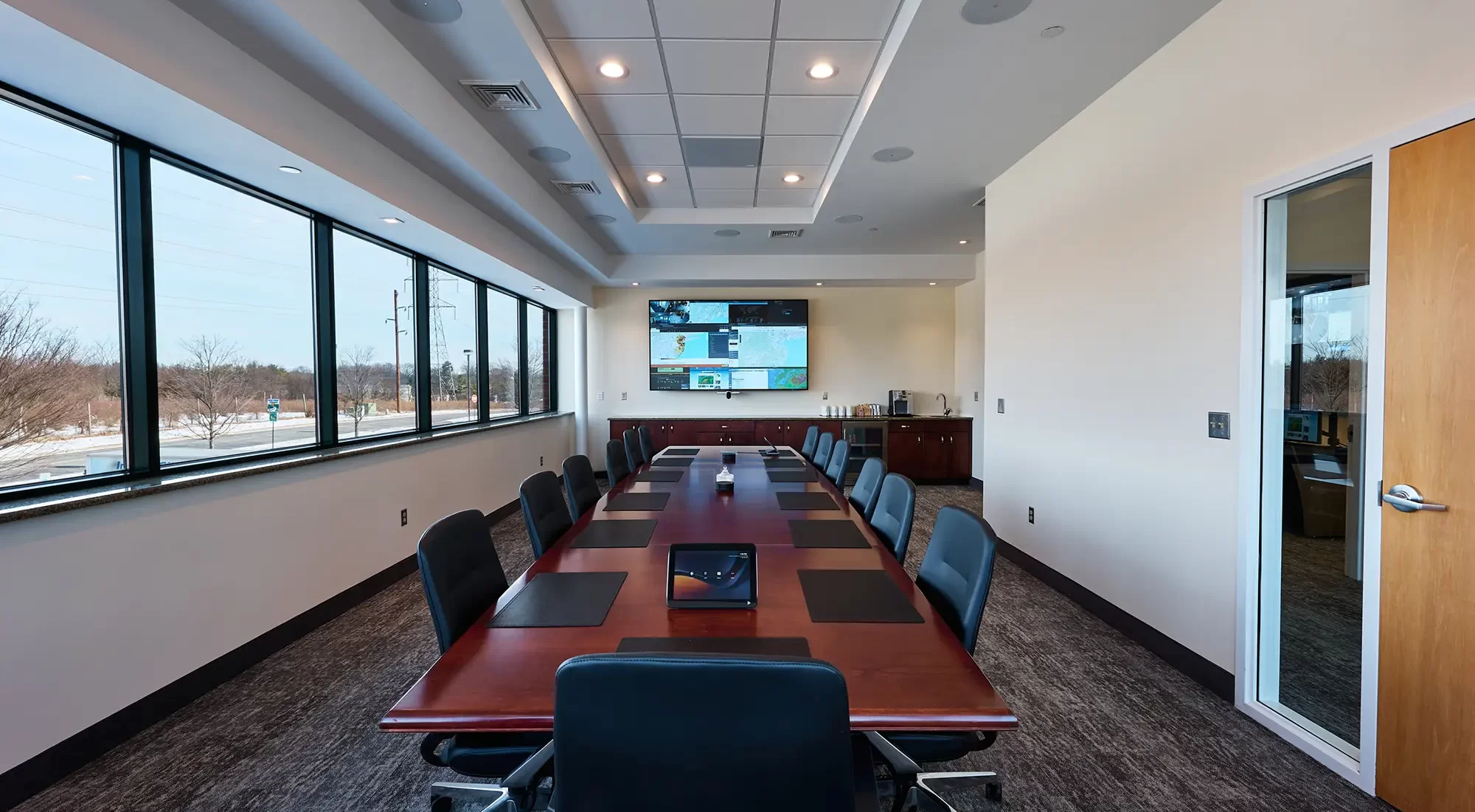 A conference room with a television and control panel.